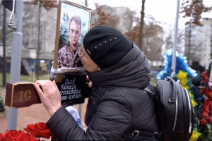 kobieta całuje krzyż na grobie żołnierza